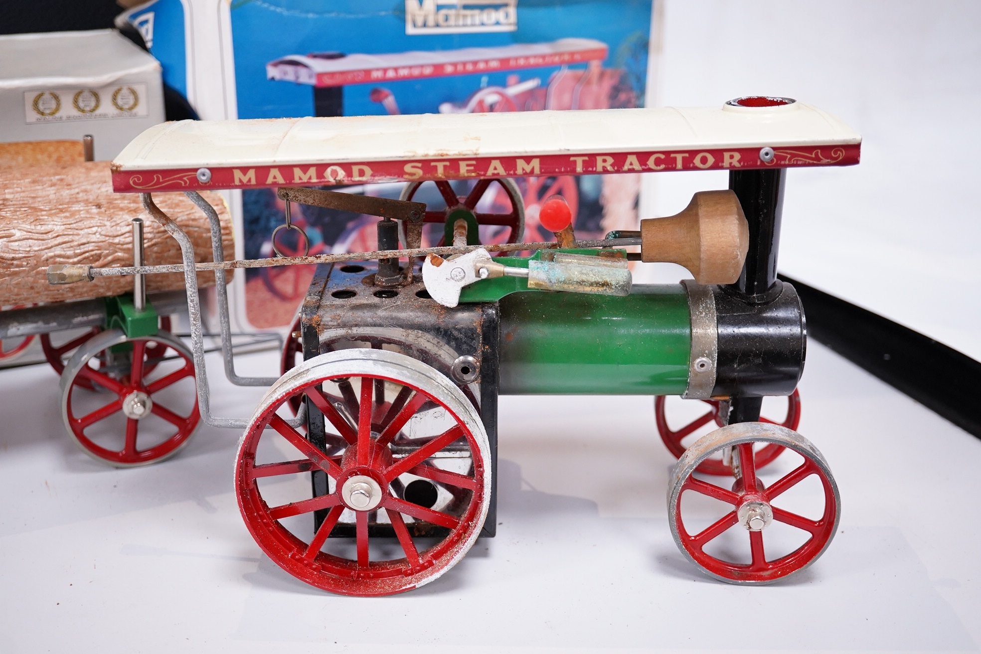 A boxed Mamod TE-1A live steam traction engine and lumber wagon. Condition - poor to fair, there is corrosion to the exposed aluminium and other metal parts.